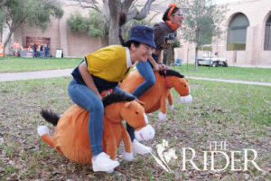 Students competing in a stuffed animal horse race.