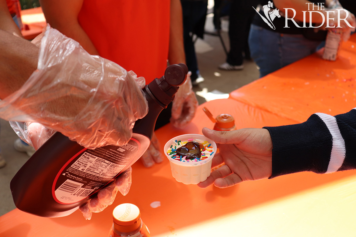 Biomedical science junior Jarret Quezada adds toppings to ice cream Aug. 26 during Sundaes on Mondays outside the Student Union on the Edinburg campus. Raquel Cazares/THE RIDER