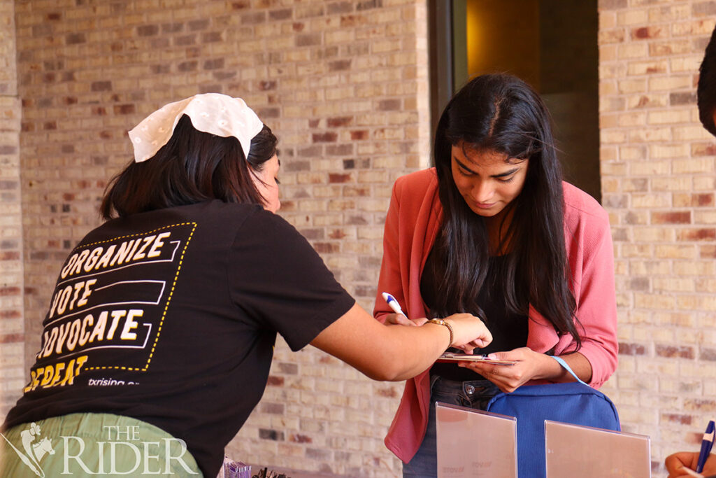 Public affairs graduate student Estrella Torres, the Texas Rising regional program coordinator, assists freshman Marelin Barrales in completing a voter registration application Oct. 7 outside the University Library on the Brownsville campus. Venisha Col贸n/THE RIDER