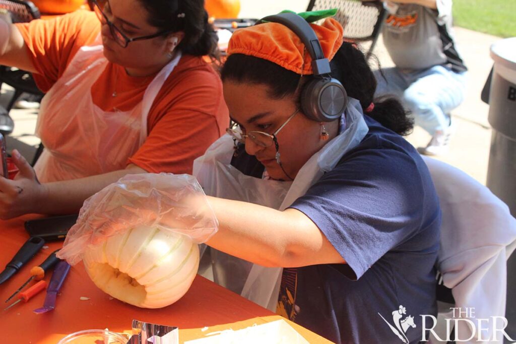 Theatre sophomore Elvira Garza carves a pumpkin during the carving/painting contest Wednesday outside the Student Union on the Edinburg campus. Raquel Cazares/THE RIDER