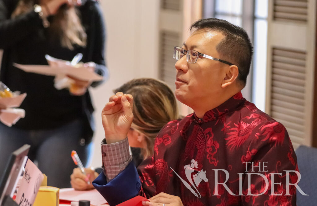 Pierre Lu, a UTRGV professor of research methodology, explains the meaning behind the calligraphy he painted for students Wednesday in the PlainsCapital Bank El Gran Sal贸n on the Brownsville campus. Mykel Del Angel/THE RIDER