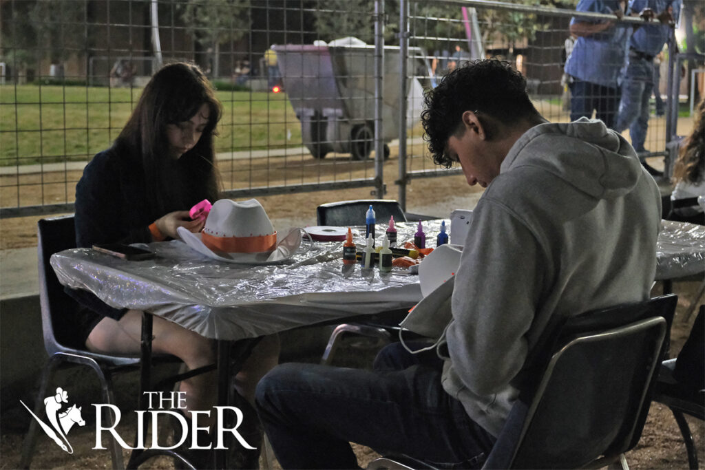 Biology junior Lauren Martinez (left) and integrated health science freshman Axel Lopez decorate cowboy hats during the Vaqueros Boots & BBQ event Thursday evening on the Quad on the Edinburg campus.
Angel Ballesteros/THE RIDER