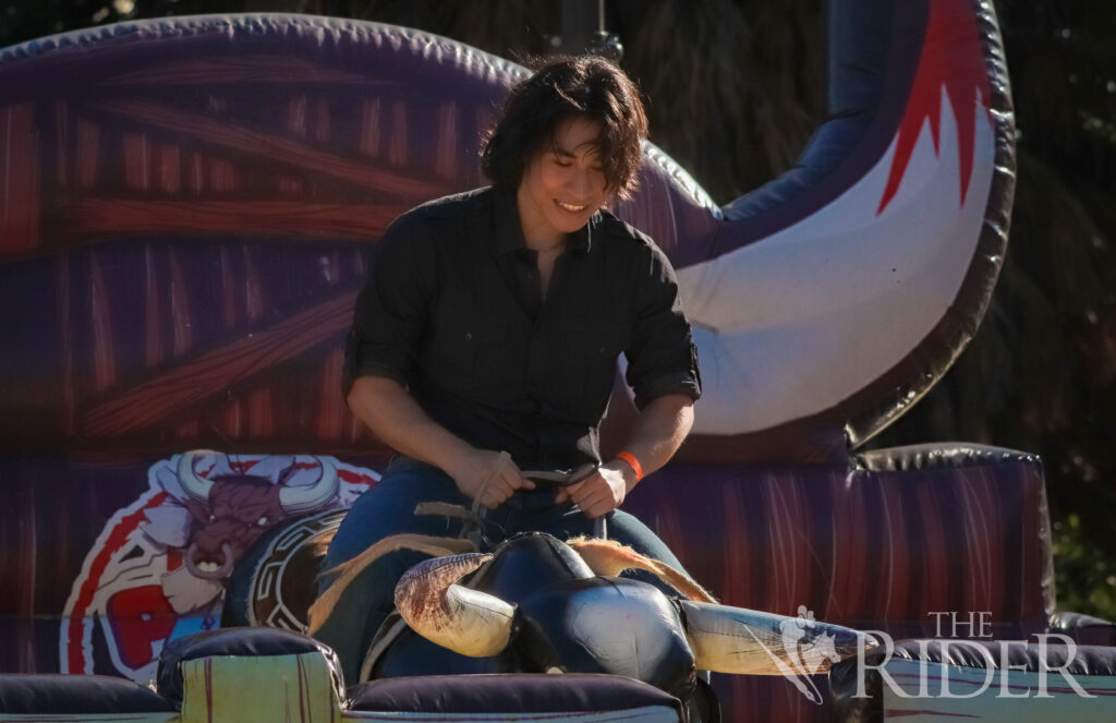 Emiliano Osorio, an integrated health science junior, rides a mechanical bull Wednesday at the Charreada on the Student Union lawn on the Brownsville campus. Mykel Del Angel/THE RIDER