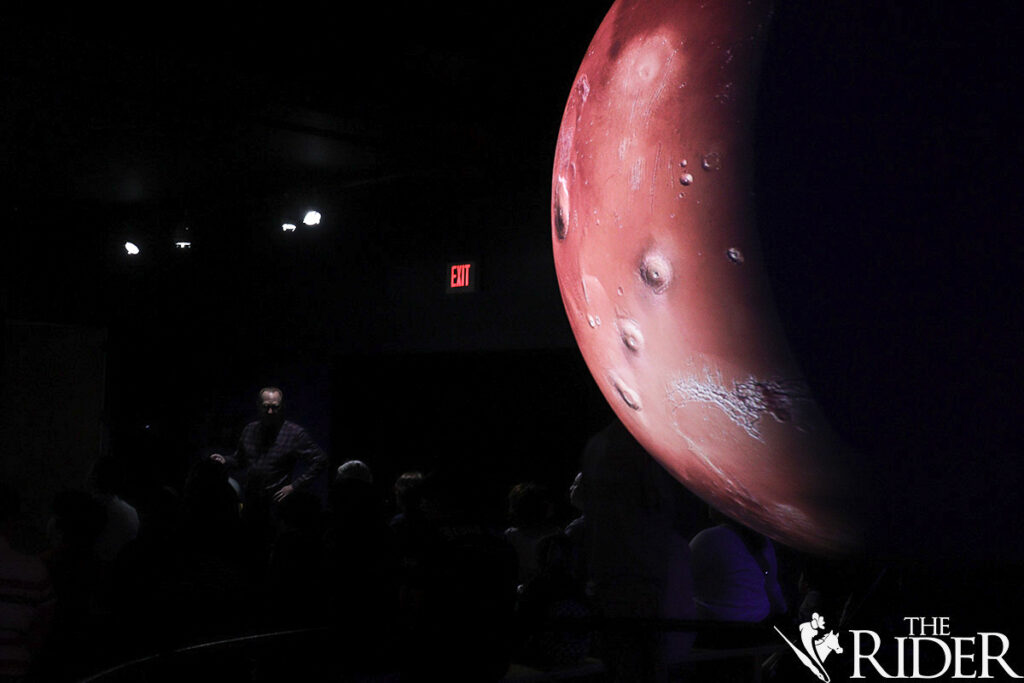 Dr. John Gerling, International Museum of Art & Science Board of Trustees member, presents while Mars is shown Thursday during Mysterious Cosmos Family Fun Nights in McAllen.
Amara Cazares/THE RIDER