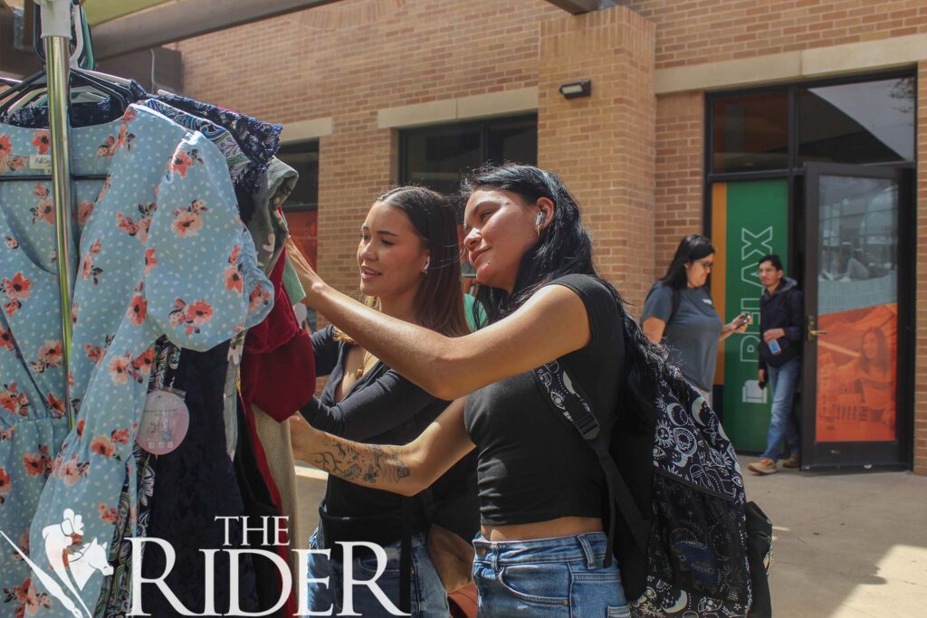 Accounting sophomore Linda Vela (left) and nutritional sciences junior Cristina Vela look for vintage clothing at a House of Fashion pop-up store Tuesday on the Student Union patio on the Edinburg campus. Jose Rodriguez/THE RIDER