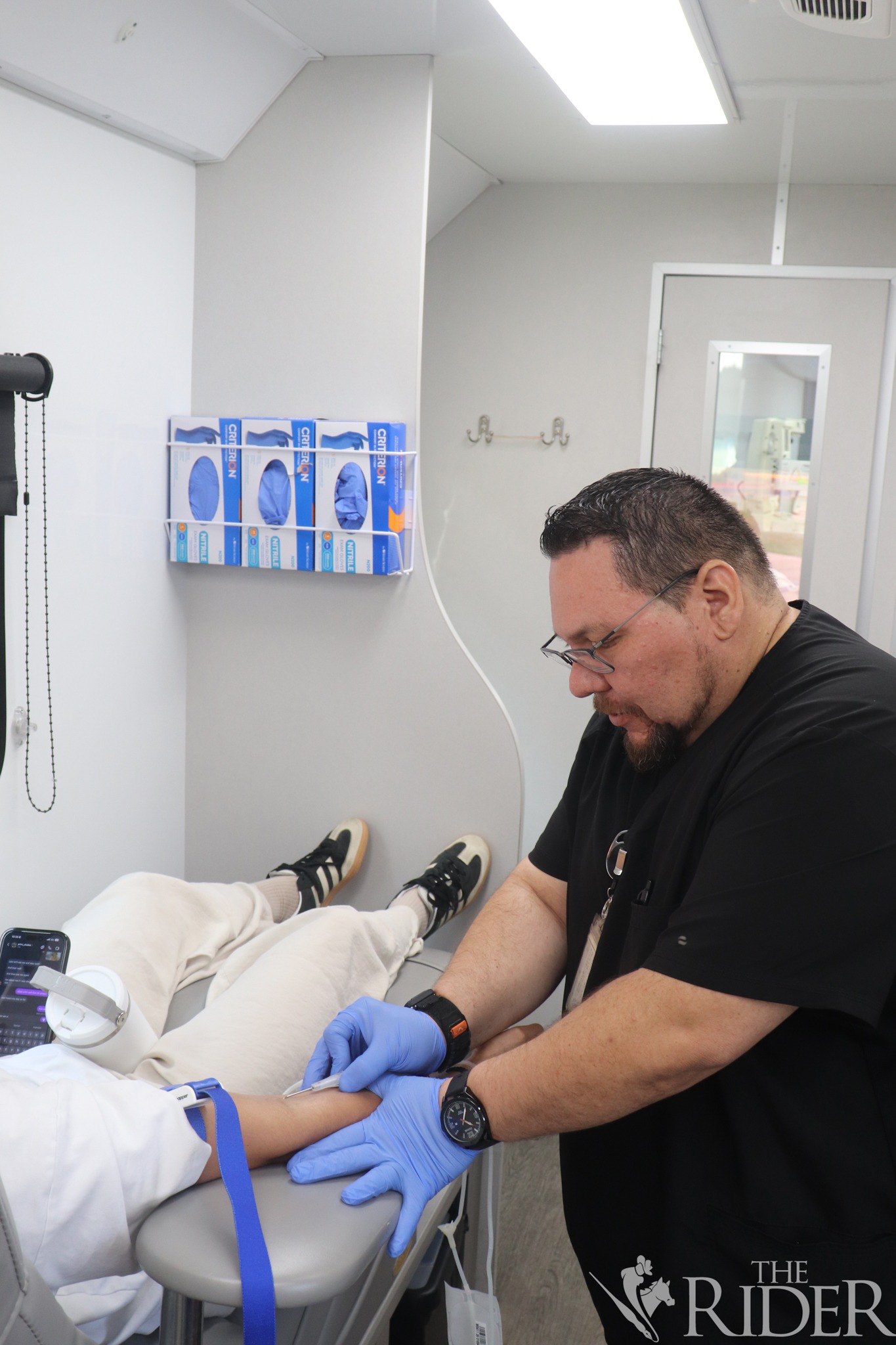 Ruben, a Vitalant staff member, prepares a participant for a blood draw during a drive Wednesday outside the Student Union on the Edinburg campus.