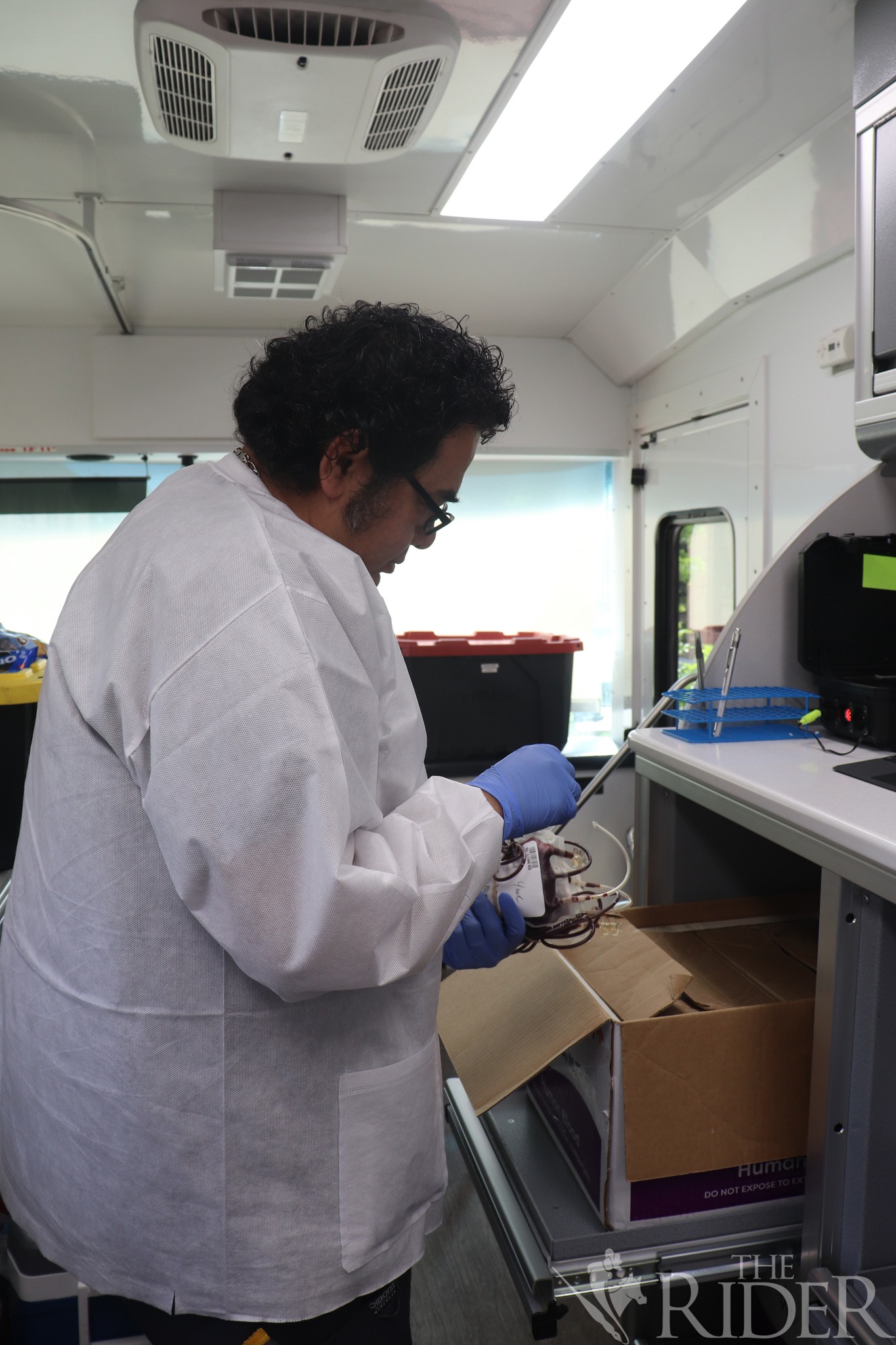 Lewie, a Vitalant staff member, handles donated blood inside a mobile donation unit during a blood drive Wednesday outside the Student Union on the Edinburg campus.